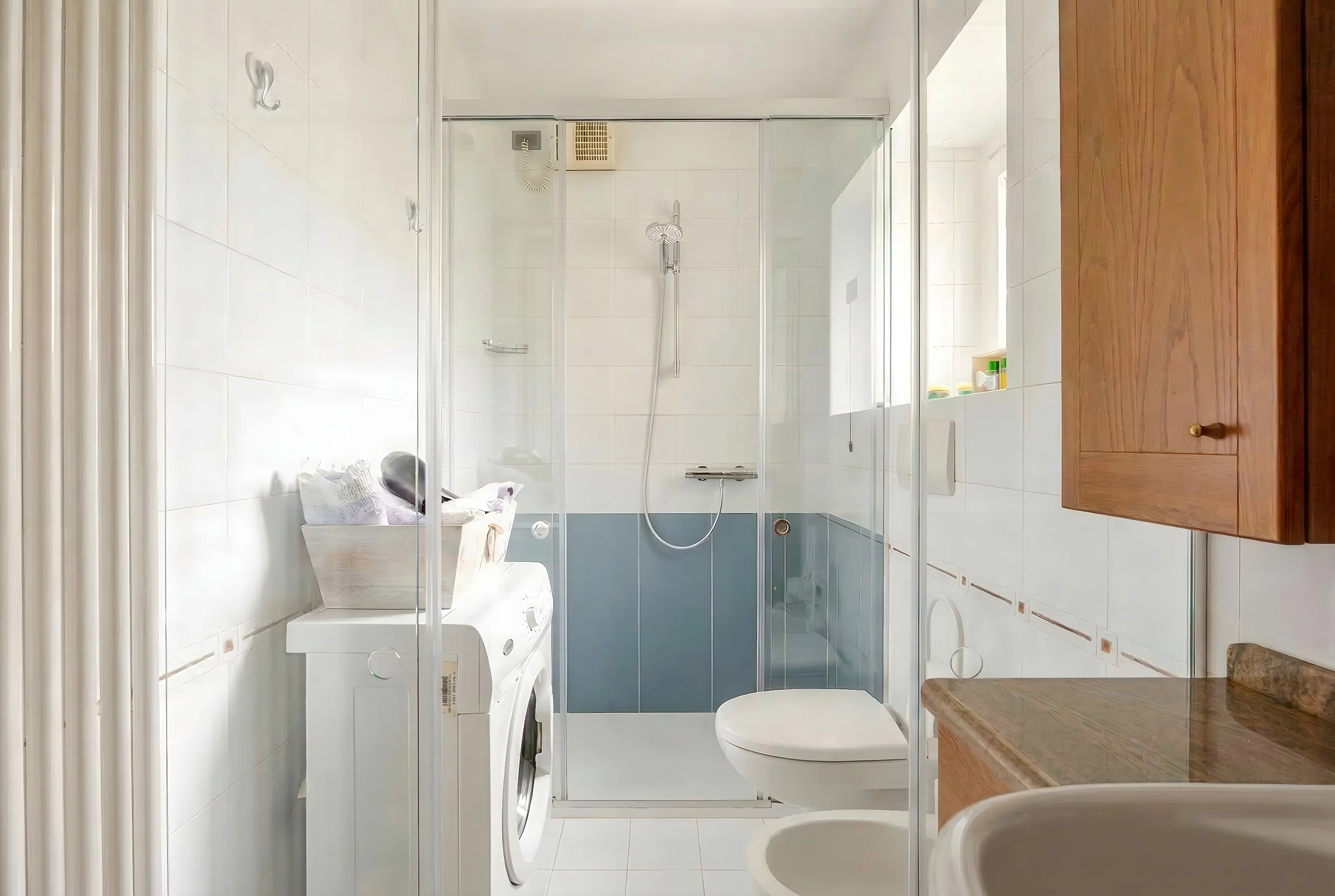 Bagno luminoso con doccia e rivestimenti azzurri