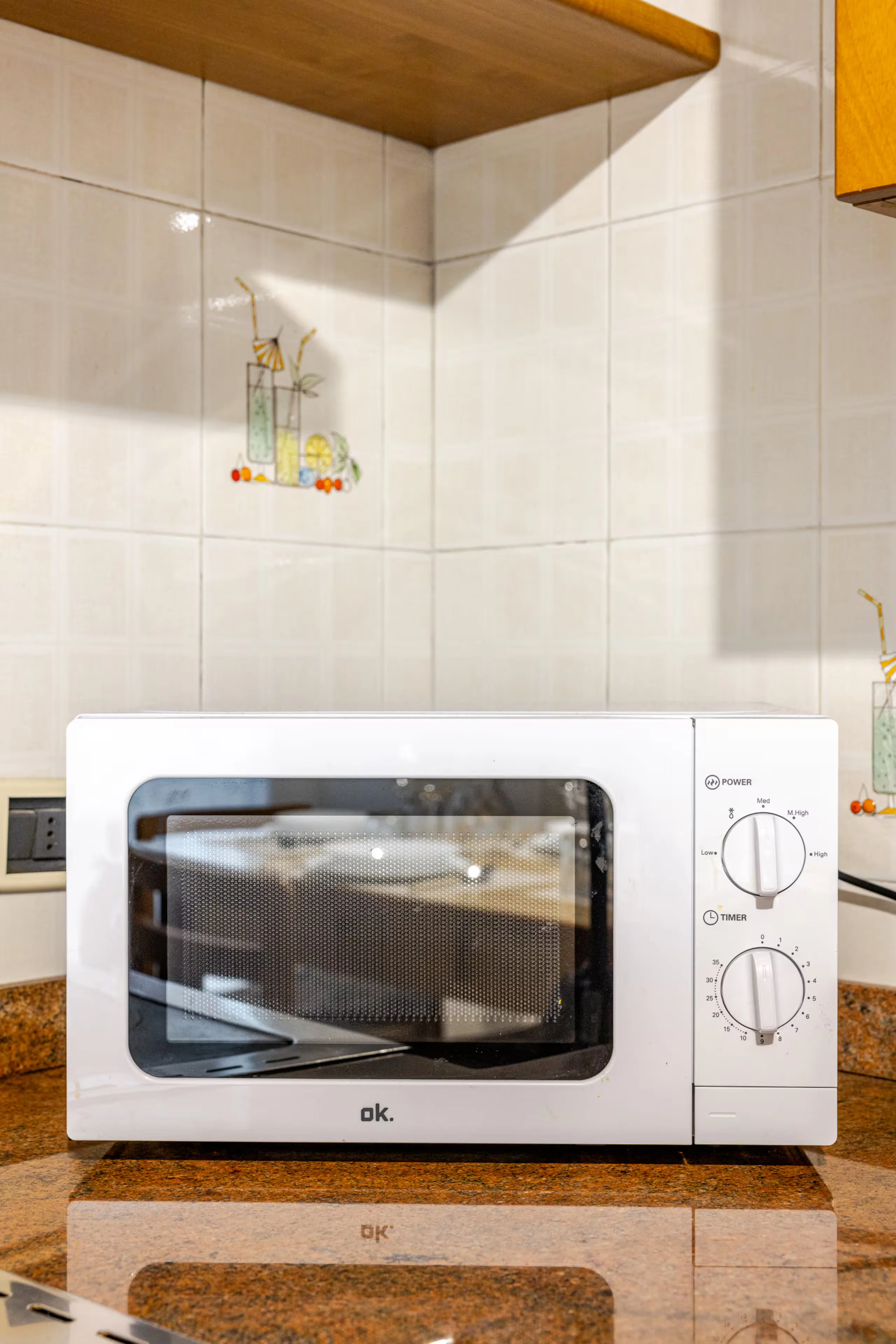 Forno a microonde bianco sul piano in legno della cucina